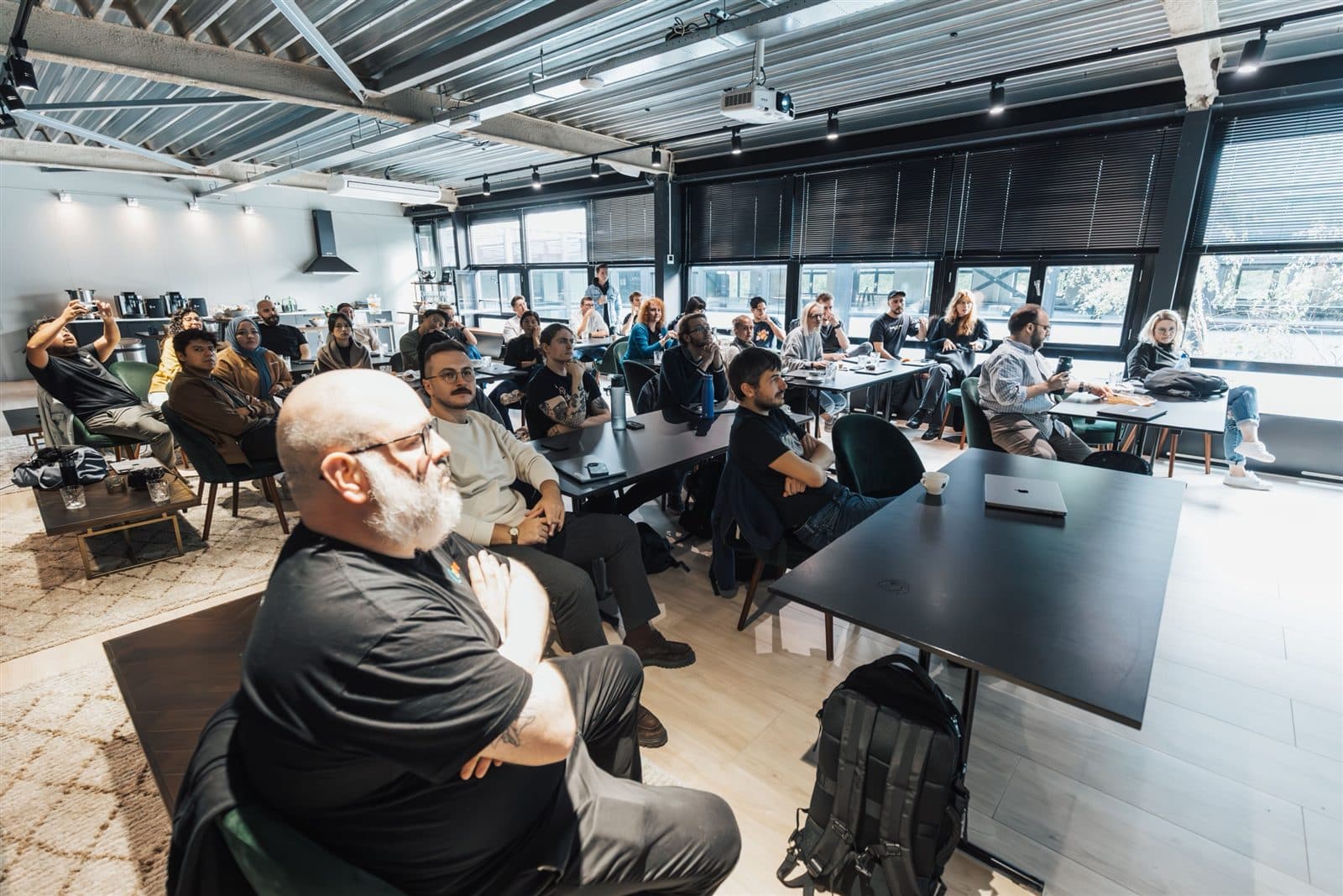 Plateia acompanha uma palestra corporativa em um auditório amplo.