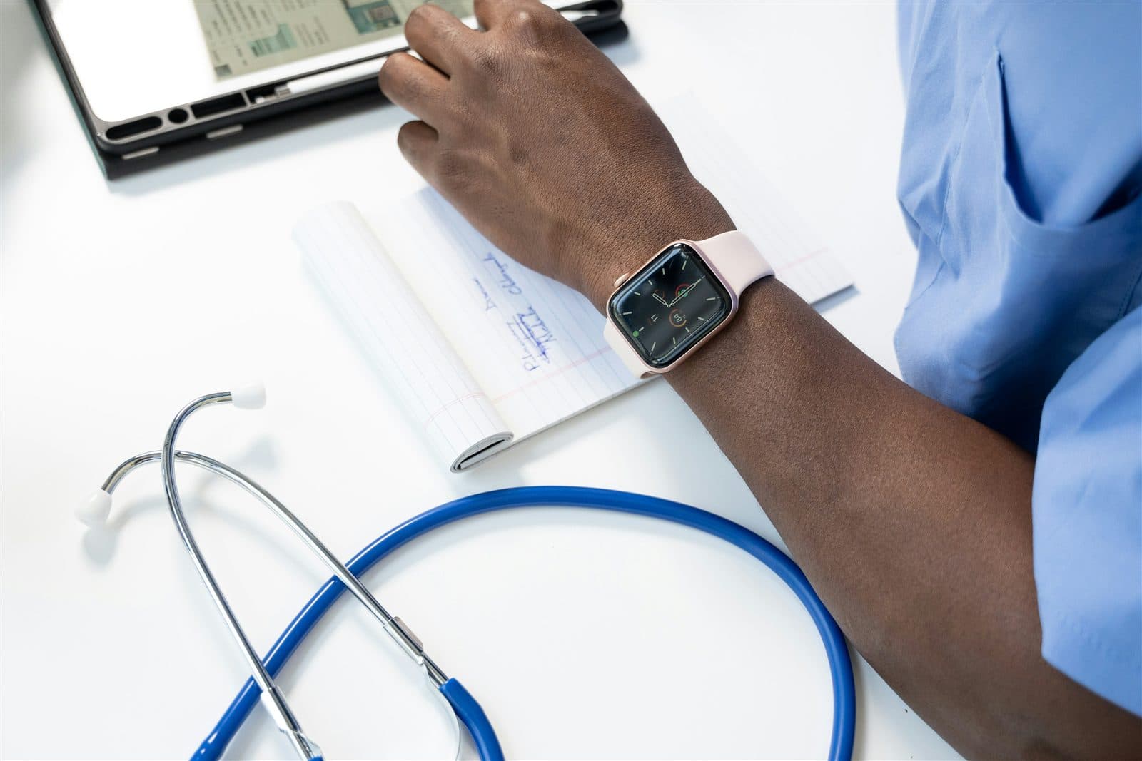 Profissional de saúde consulta indicadores em um smartwatch durante o acompanhamento.